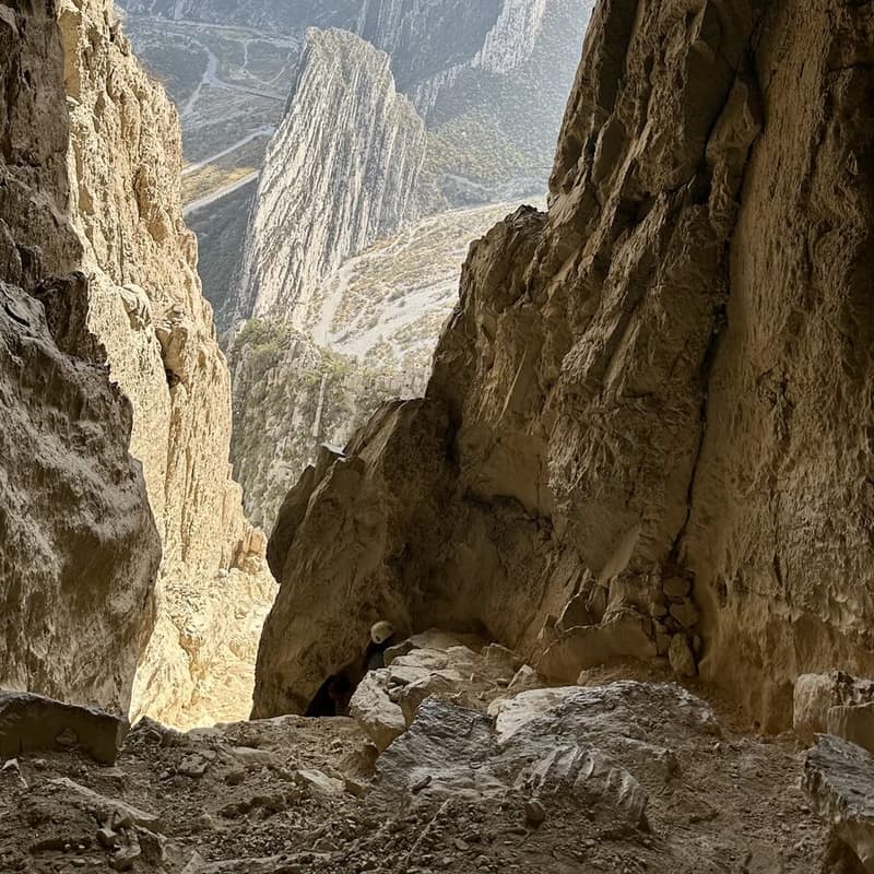 Boca de la Cueva de la Virgen entre paredes de roca, con el valle al fondo