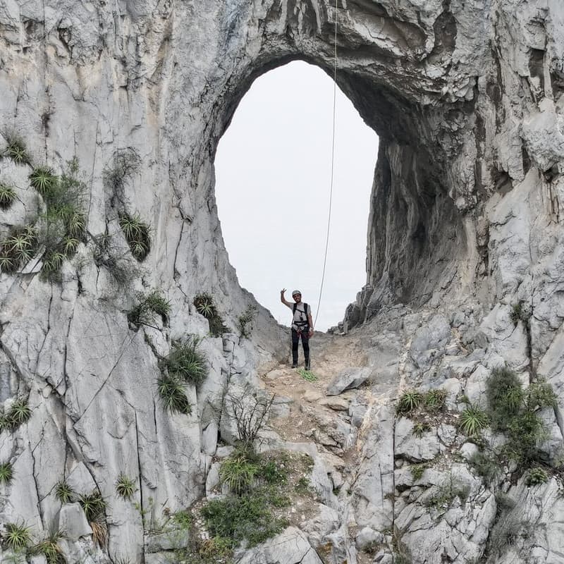 Persona de pie dentro del arco de roca del Nido del Aguilucho